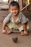 Hmong tribe boy playing with a home-made top