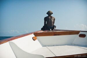 Dive master riding on the front of our bouncing boat