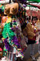 Vendor selling trinkets, boas, hats, and plastic boobs