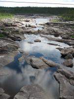 Reflections in still water and massive boulders
