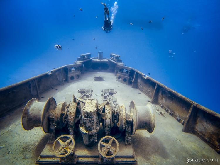 A scuba diver hovering above the bow of the USS Kittiwake shipwreck, an artificial reef off Grand Cayman