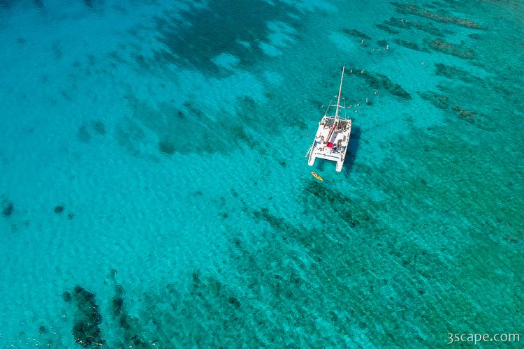 Aerial view of a catamaran anchored over shallow turquoise water near Grand Cayman's North Sound