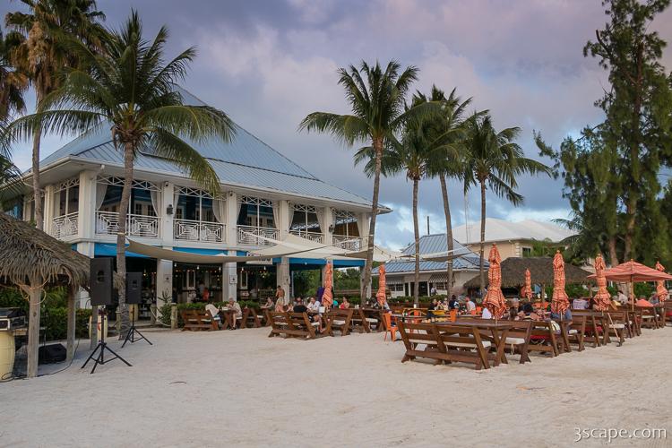 Kaibo Beach Bar and Grill restaurant on the sand in Grand Cayman, with palm trees and outdoor seating at dusk