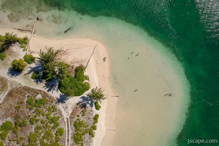 Aerial view of Starfish Point, a sandy shoreline in Grand Cayman with people wading in shallow green water