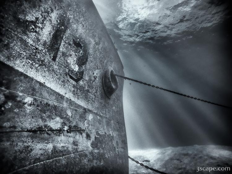 Close-up black and white photo of the USS Kittiwake's bow and anchor chain, underwater off Grand Cayman