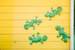 Next Image: Green Geckos on Yellow Wall