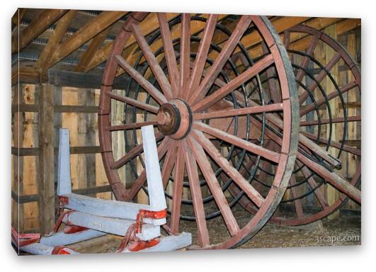 An old logging wheel and sliegh Fine Art Canvas Print