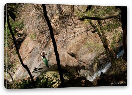 Rappelling down the cable over a waterfall Fine Art Canvas Print