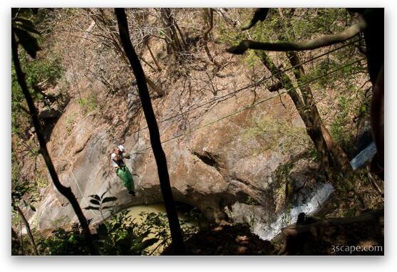 Rappelling down the cable over a waterfall Fine Art Metal Print